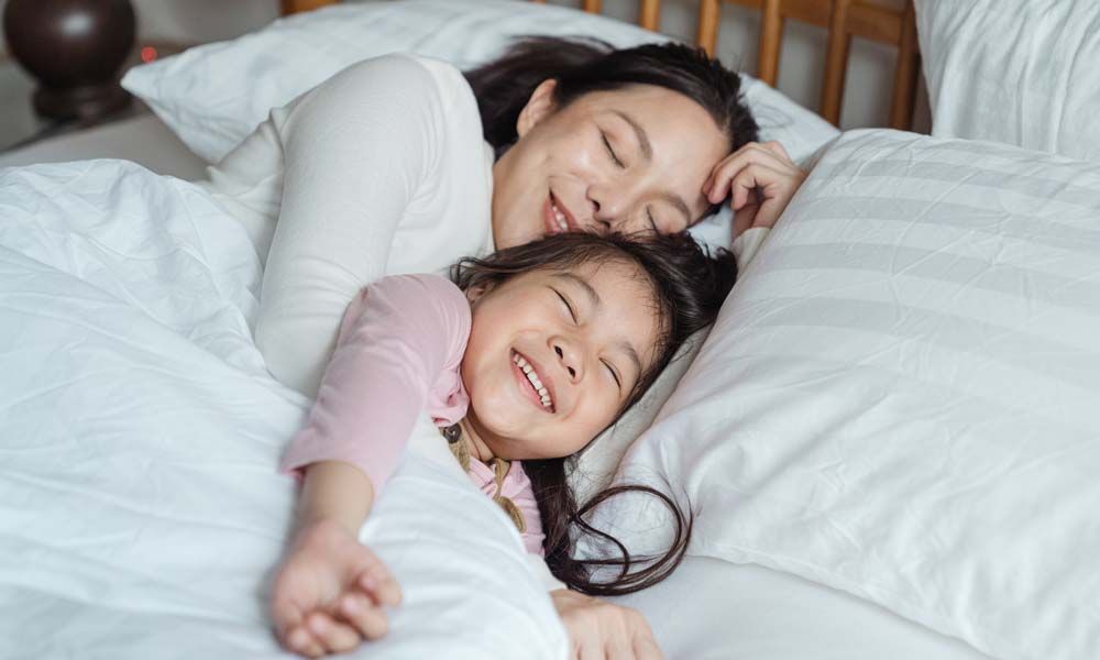 A mother and daughter sleeping peacefully in a bedroom.